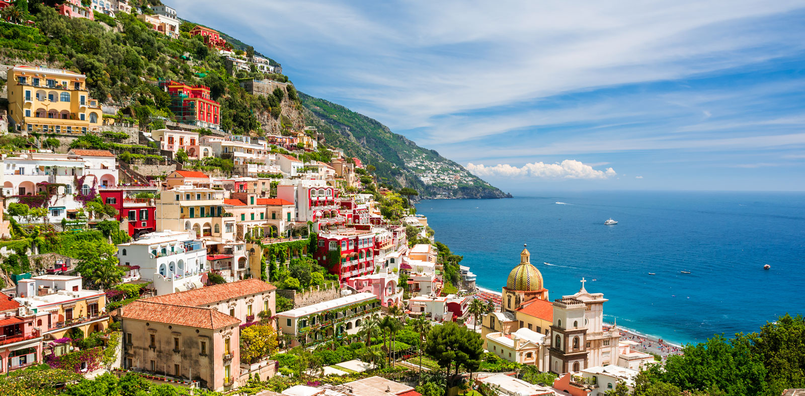 Positano an der Amalfiküste mit bunten Häusern und Yachten im kristallklaren Wasser