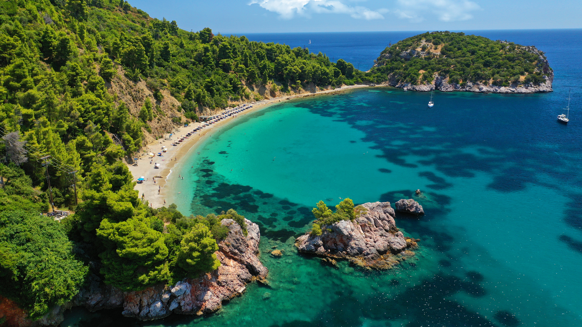 Türkisfarbene Bucht mit bewaldeter Küste in Griechenland