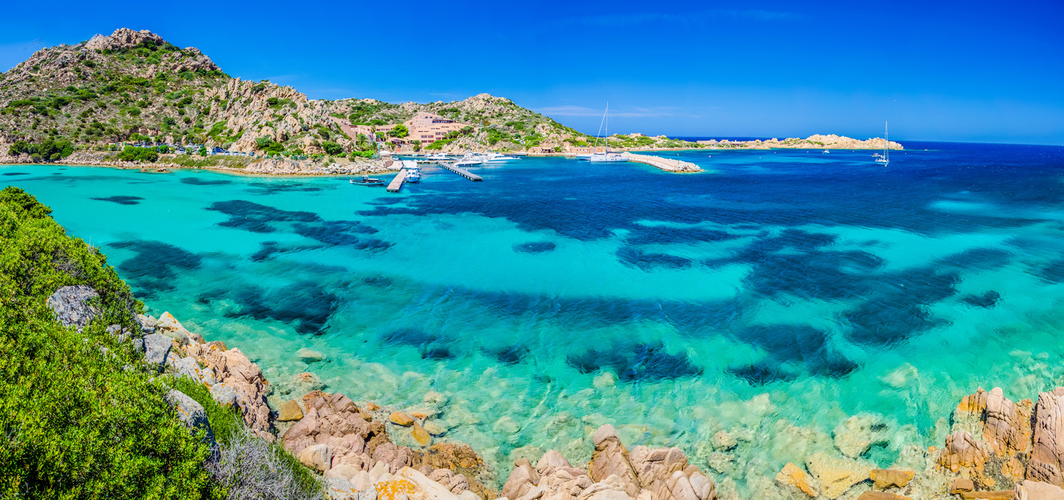 Yachtcharter Costa Smeralda - Luxusyachten ankern in türkisblauer Bucht mit Granitfelsen an der Smaragdküste Sardiniens, perfekt für exklusiven Segelurlaub