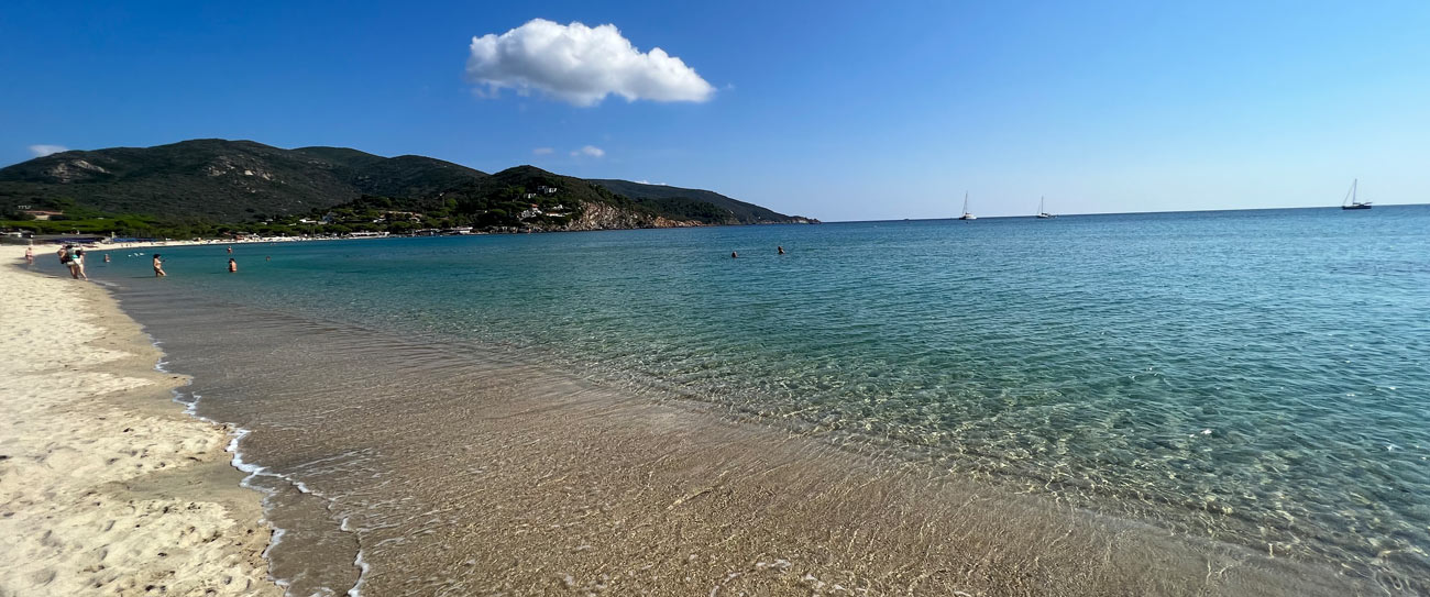 Traumhafte Bucht in der Toskana mit türkisfarbenem Wasser und Segelbooten
