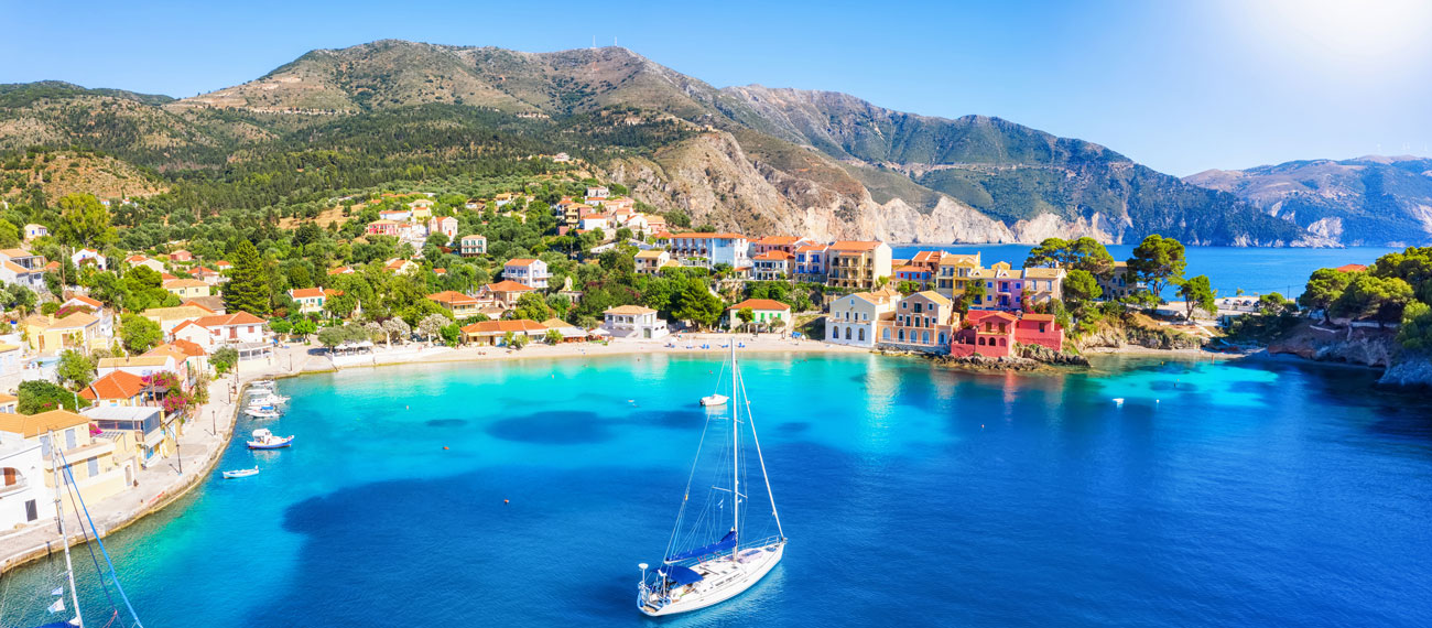 Yachtcharter Ionische Inseln - Segelboot vor grünen Küsten von Korfu und Lefkada bei ruhiger See