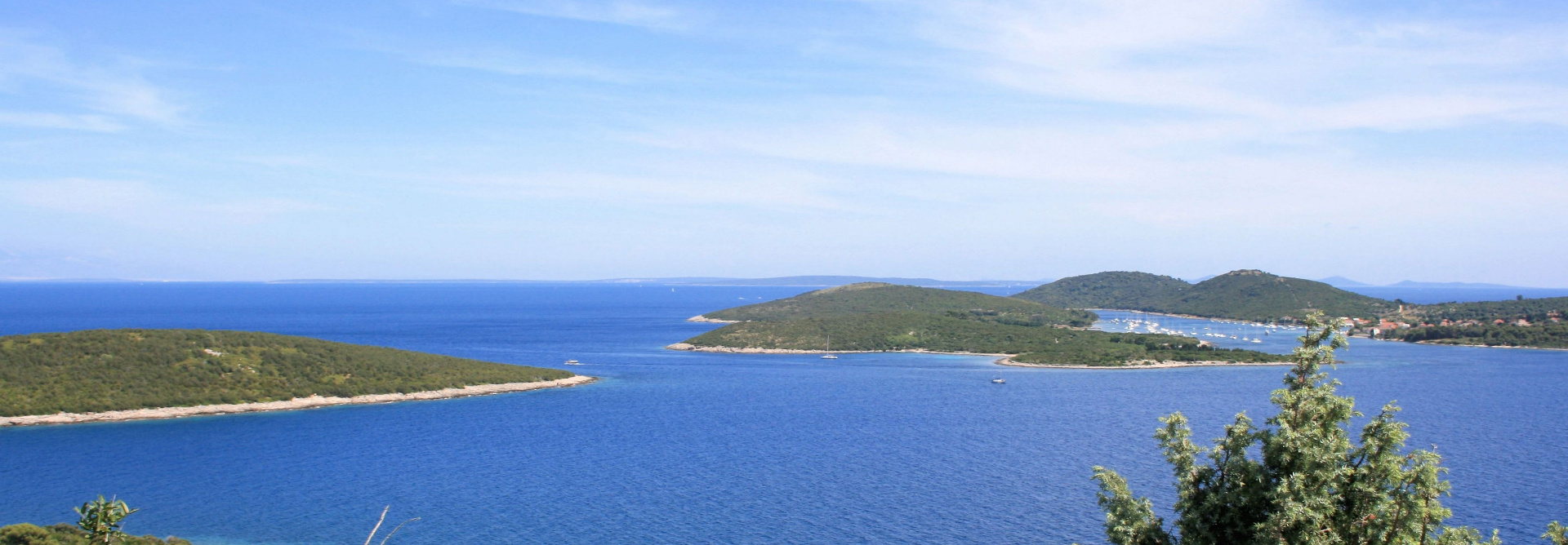 Kristallklares blaues Wasser und grüne Inseln der Kvarner Bucht unter blauem Himmel