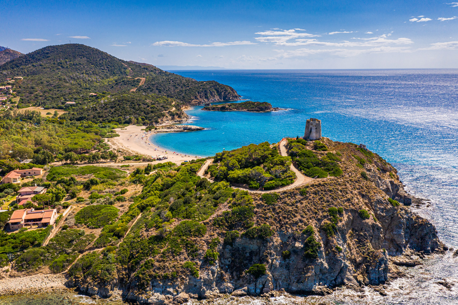 Luftaufnahme der sardischen Küste mit historischem Wachturm auf Klippe und türkisfarbenem Meer, typisch für das La Maddalena Archipel